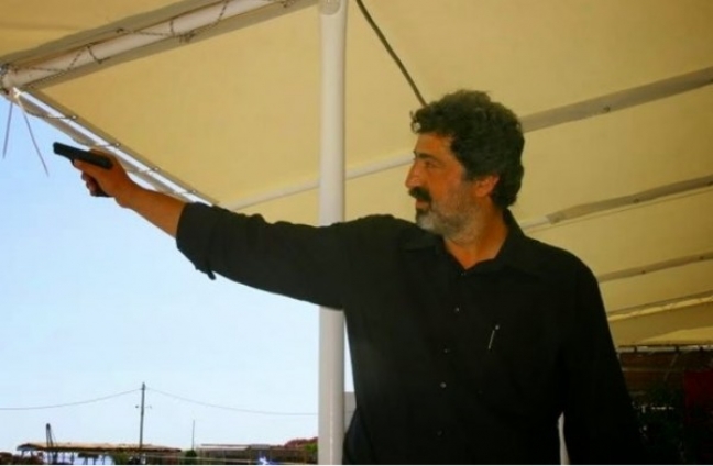 Ο Αναπληρωτής υπουργός Υγείας Παύλος Πολάκης, με όπλο, σε μια φωτογραφία πριν την υπουργοποίησή του. Κατά τον δημοσιογράφο Παύλο Τσίμα, «έχει το ακαταλόγιστο, το πρόβλημά μου δεν είναι ο κύριος Πολάκης, είναι ότι οι συνάδελφοί του στο υπουργικό συμβούλιο, όσο παραμένει, θεωρούν συμβατή τη γλώσσα και την κουλτούρα της Χρυσής Αυγής σε μια δημοκρατική κυβέρνηση».