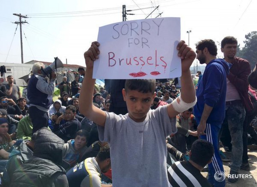 Ειδομένη Κιλκίς, 22 Μαρτίου 2016. «Λυπάμαι για τις Βρυξέλλες» λέει το πανώ που κρατά μικρός πρόσφυγας. 