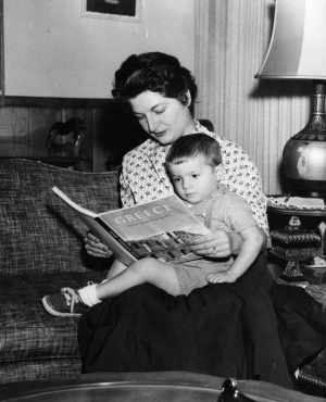 Η φωτογραφία υπήρχε στο αρχείο της εφημερίδας Valley Times, που εκδιδόταν από το 1946 ώς το 1970 στην περιοχή San Fernando Valley της Καλιφόρνιας. Η φωτογραφία έχει τραβηχτεί στις 13 Νοεμβρίου 1956 και η λεζάντα που τη συνοδεύει λέει: «Η κυρία Ντένα Πίκουλας από το Βόρειο Χόλιγουντ θυμίζει στον υιοθετημένο έλληνα ορφανό της, Πέτρο, δυόμισι χρονών, αρχαίες ελληνικές παραδόσεις. Η κυρία Πίκουλας και ο σύζυγός της έφεραν το ορφανό από την Ελλάδα, αφού ανακάλυψαν ότι θα έπρεπε να περιμένουν περισσότερο από ένα χρόνο για να υιοθετήσουν παιδί στις ΗΠΑ».     