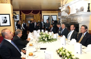 Ιούλιος 2017, Κραν Μοντανά, Ελβετία. Συνάντηση των βασικών διαπραγματευτών σε γεύμα εργασίας. Αριστερά, ο υπουργός Εξωτερικών της Τουρκίας Μεβλούτ Τσαβούσογλου, δεξιά ο κύπριος πρόεδρος Νίκος Αναστασιάδης. Διακρίνεται και ο τότε ηγέτης των Τουρκοκυπρίων, Μουσταφά Ακιντζί.