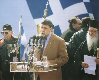 14 Φεβρουαρίου 1992, Θεσσαλονίκη. Ένα τεράστιο συλλαλητήριο δονεί την πόλη, με τη συμμετοχή σχεδόν όλων των πολιτικών κομμάτων, ακόμα και του μεγαλύτερου μέρους του Συνασπισμού, για το όνομα της γειτονικής χώρας που προέκυψε από τη διάλυση της Γιουγκοσλαβίας.  Στο βήμα, τρεις τυπικοί εκπρόσωποι του ελληνικού εθνικισμού: ένας μακεδονομάχος, ο δήμαρχος  Κωνσταντίνος Κοσμόπουλος και ο μητροπολίτης Παντελεήμων, ορίζουν τα συνθήματα και τη ρητορική ενός ακόμα μετώπου αντιπαλότητας που έγινε συστατικό στοιχείο της εθνικής ιδεολογίας - πάνω στην οποία βρήκε πρόσφορο έδαφος η Χρυσή Αυγή.