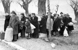 25 Μαρτίου 1944, Ιωάννινα. Οι Ρωμανιώτες Εβραίοι της πόλης έχουν συγκεντρωθεί πλάι στη λίμνη και ετοιμάζονται να επιβιβαστούν σε καμιόνια, με προορισμό τη Λάρισα, όπου θα επιβιβάζονταν σε τρένα για το στρατόπεδο Άουσβιτς-Μπιρκενάου. Μόλις έφτασαν εκεί, σχεδόν όλοι εξοντώθηκαν.    