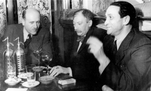 To καφέ σαν γραφείο: Ο Γιόζεφ Ροτ (στο κέντρο) και ο εβραιοουκρανός δημοσιογράφος και συγγραφέας Σόμα Μόργκενστερν (δεξιά), με έναν καλεσμένο τους, στο Café Le Tournon, στο Παρίσι, γύρω στο 1938. 