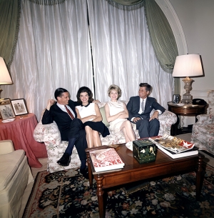 1963. Ο αμερικανός πρόεδρος Τζον Κένεντι και η σύζυγός του Τζάκι (αριστερά) με το διευθυντή σύνταξης της Washington Post, Μπέντζαμιν Κ. Μπράντλι και τη σύζυγό του, στο σαλόνι του προεδρικού ζεύγους, στον Λευκό Οίκο. Η στενή φιλική σχέση του Κένεντι και του Μπράντλι και των οικογενειών τους είναι χαρακτηριστικό παράδειγμα αυτής της «αιμομεικτικής σχέσης» Τύπου-εξουσίας.