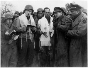 29 Οκτωβρίου 1944, Άαχεν, Γερμανία. Εβραίοι που πολέμησαν κατά των Γερμανών παρευρίσκονται στην πρώτη δημόσια εβραϊκή λειτουργία που τελέστηκε σε γερμανικό έδαφος μετά την άνοδο του Χίτλερ, επωφελούμενοι από τις ήττες που ήδη είχε υποστεί η γερμανική πολεμική μηχανή. Αριστερά, με το σάλι προσευχής, ο Γερμανοεβραίος Μαξ Φουκς, από το αρχείο του οποίου προέρχεται αυτή η φωτογραφία.   
