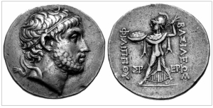 Ο Φίλιππος Ε΄ ο Μακεδών (221-179 π.Χ.), όπως απεικονίζεται σε ασημένιο τετράδραχμο του βασιλείου του, που ματαίως ελάχιστοι Έλληνες έλπιζαν ότι θα μπορούσε να είναι ασπίδα όλης της Ελλάδας απέναντι στην κατακτητική μηχανή των Ρωμαίων. Στο ατελές ποίημα του Καβάφη «Αγέλαος», γράφει ο Αλεξανδρινός: «Στην συνεδρίασιν της Ναυπάκτου ο Αγέλαος / μίλησε τα σωστά. Μη πολεμάτε πια / οι Έλληνες τους Έλληνας. Κοντά μας ο αγών /  γίνεται που μας απειλεί. Είτε η Καρχηδών / νικήσει είτε η Ρώμη, / προς ημάς κατόπιν θα στραφεί. Ω βασιλεύ / Φίλιππε, […] σώσε την Ελλάδα. // Λόγια σοφά. Μα δεν έπιασαν τόπο. / Στες φοβερές, επάρατες ημέρες / των Κυνός Κεφαλών, της Μαγνησίας, της Πύδνας, / πολλοί εκ των Ελλήνων θα θυμήθηκαν / τα λόγια τα σοφά, που δεν έπιασαν τόπο».  