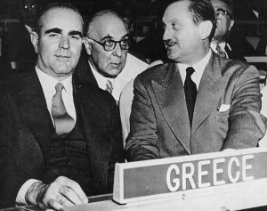 12 Νοεμβρίου 1956, Νέα Υόρκη, στην έδρα των Ηνωμένων Εθνών. Ο πρωθυπουργός Κωνσταντίνος Καραμανλής (αριστερά) και ο υπουργός του των Εξωτερικών Ευάγγελος Αβέρωφ (δεξιά) συμβουλεύονται τον διευθυντή της Β’ Πολιτικής Διεύθυνσης του υπουργείου Εξωτερικών, Γιώργο Σεφέρη, στη διάρκεια διαπραγματεύσεων για την ανεξαρτητοποίηση της Κύπρου. Η φωτογραφία, από αφιέρωμα του ενθέτου «7 Ημέρες» της Καθημερινής.  
