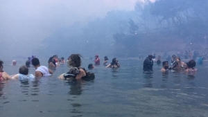 23 Ιουλίου 2018, Αργυρά Ακτή, Μάτι, Αττική. Άνθρωποι έχουν πέσει στη θάλασσα για να γλιτώσουν από την πυρκαγιά. Ο Νίκος Βερυκοκκίδης κατέγραψε με την κάμερα του κινητού του τα δραματικά περιστατικά.  