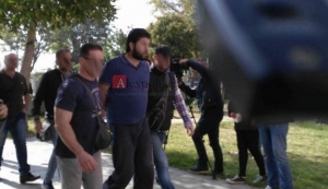 Αστυνομικοί της αντιτρομοκρατικής ενώ προσάγουν στις δικαστικές αρχές τον φερόμενο ως τζιχαντιστή, που συνελήφθη στην Αλεξανδρούπολη. Καρέ από λήψη τοπικού τηλεοπτικού σταθμού.
