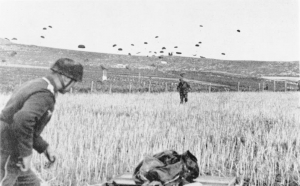 20 Μαΐου 1941. Γερμανός αλεξιπτωτιστής έχει προσγειωθεί σε χωράφι, στο έδαφος της Κρήτης, ενώ πολλοί ακόμα συνάδελφοί του ετοιμάζονται με τη σειρά τους να προσγειωθούν.