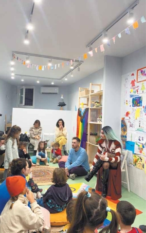 Στιγμιότυπο από την εκδήλωση που διοργανώθηκε στις 30 Δεκεμβρίου 2022, σε νηπιαγωγείο της Θεσσαλονίκης, από το Thessaloniki Prida και τις Οικογένειες Ουράνιο Τόξο. Στην εκδήλωση αυτή, διεμφυλικά άτομα διάβασαν παραμύθια σε μικρά παιδιά. 