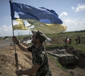 24 Φεβρουαρίου 2022. Ουκρανός στρατιωτικός υψώνει τη σημαία της χώρας του, δηλώνοντας την πρόθεση των ουκρανικών δυνάμεων να αντισταθούν στη ρωσική εισβολή. 