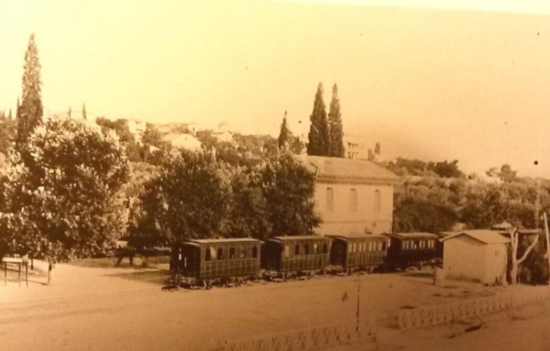 To θηρίο, το πρώτο τρένο της Αττικής, η γραμμή του οποίου Αθήνα-Κηφισιά εγκαινιάστηκε το 1885. Η φωτογραφία που μνημειώνει το σταθμό της Κηφισιάς, το 1890, έχει τραβηχτεί από τον Παύλο Μελά.  