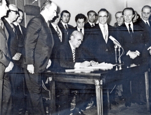 &Iota;&omicron;ύ&nu;&iota;&omicron;&sigmaf; 1975. &Omicron; &pi;&rho;&omega;&theta;&upsilon;&pi;&omicron;&upsilon;&rho;&gamma;ό&sigmaf; &Kappa;&omega;&nu;&sigma;&tau;&alpha;&nu;&tau;ί&nu;&omicron;&sigmaf; &Kappa;&alpha;&rho;&alpha;&mu;&alpha;&nu;&lambda;ή&sigmaf; &upsilon;&pi;&omicron;&gamma;&rho;ά&phi;&epsilon;&iota; &tau;&omicron; &nu;έ&omicron; &Sigma;ύ&nu;&tau;&alpha;&gamma;&mu;&alpha;, &tau;&omicron;&nu; &kappa;&alpha;&tau;&alpha;&sigma;&tau;&alpha;&tau;&iota;&kappa;ό &chi;ά&rho;&tau;&eta; &tau;&eta;&sigmaf; &delta;&eta;&mu;&omicron;&kappa;&rho;&alpha;&tau;&iota;&kappa;ή&sigmaf; &Mu;&epsilon;&tau;&alpha;&pi;&omicron;&lambda;ί&tau;&epsilon;&upsilon;&sigma;&eta;&sigmaf;, &pi;&omicron;&upsilon; &sigma;&upsilon;&nu;έ&delta;&epsilon;&sigma;&epsilon; &tau;&eta;&nu; &Epsilon;&lambda;&lambda;ά&delta;&alpha; &mu;&epsilon; &tau;&eta;&nu; &Epsilon;&upsilon;&rho;ώ&pi;&eta;.