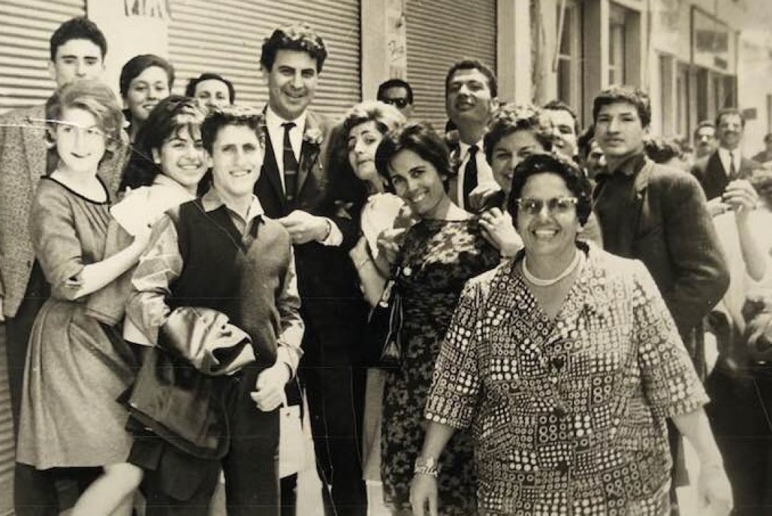 1962 ή 1963, στην Κοκκινιά. Ήταν η εποχή που ο Μίκης Θεοδωράκης είχε δημιουργήσει μια χορωδία στην οποία συμμετείχε και το μέλος των Λαμπράκηδων, μαθητής νυχτερινού γυμνασίου, Παναγιώτης Ιωακειμίδης, που στη φωτογραφία στέκεται μπροστά από τον συνθέτη.